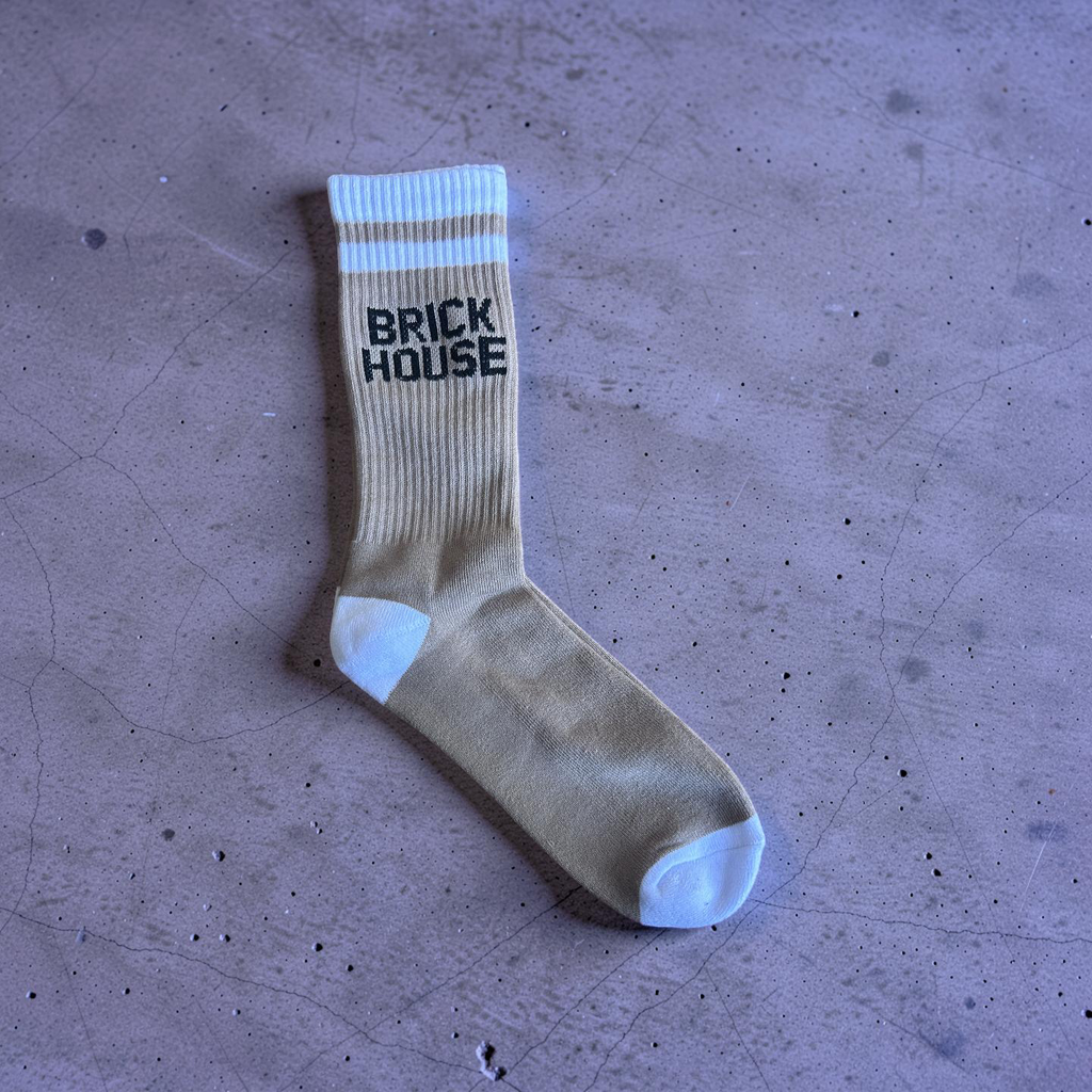 Beige sock with 'BRICK HOUSE' text on a textured surface