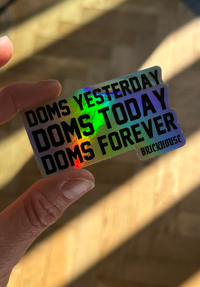 Holographic sticker with text held by a hand against a blurred background