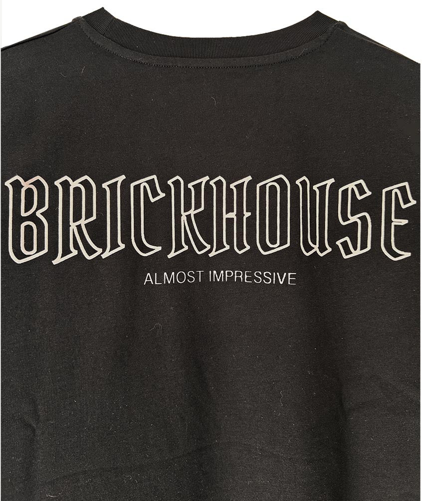 Black t-shirt with 'BRICKHOUSE Almost Impressive' text on a plain background