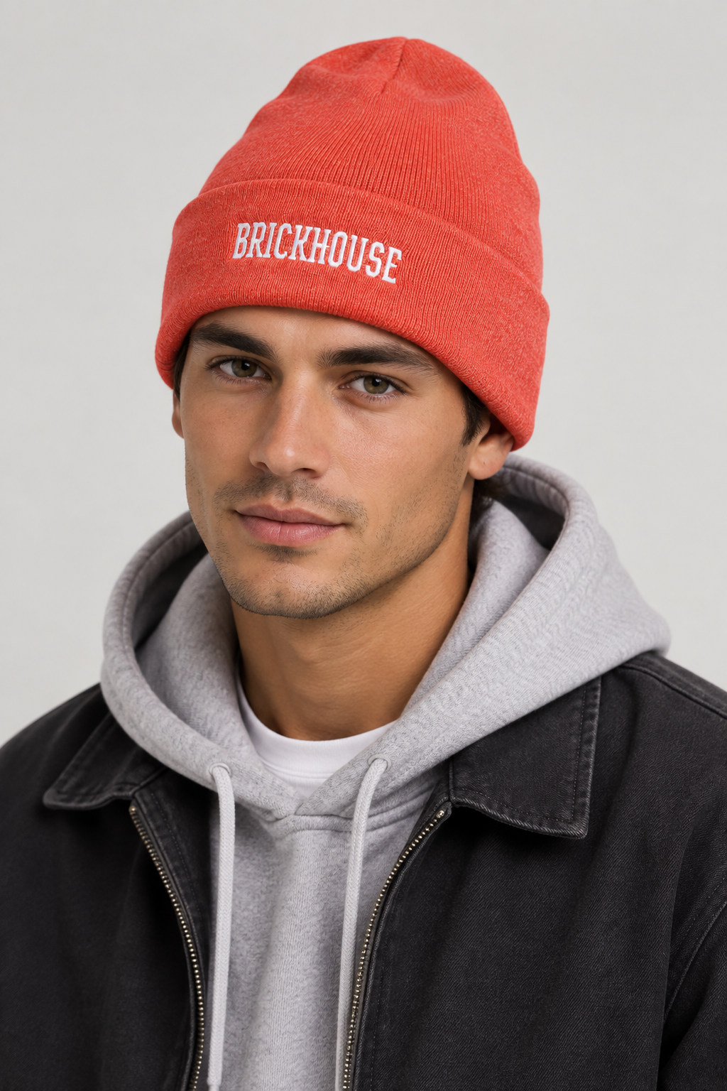 Model wearing the coral-orange Brickhouse beanie
